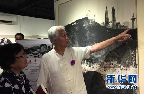 中国侨网4月11日，钟正山“山”系列水墨画展，钟正山（右）向参观者介绍他创作的水墨画作品的内涵。新华网记者王大玮 摄