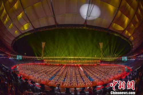 中国侨网万人献礼海南建省办经济特区30周年，同跳竹竿舞破世界纪录。　骆云飞　摄