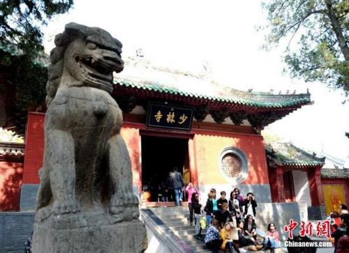 中国侨网资料图，图为一些游客在少林寺山门前合影留念。 王中举 摄