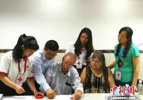 中国侨网图为菲利普家人在翻译和器官捐献协调员的指导下填写遗体器官捐献志愿书。重庆市红十字会供图