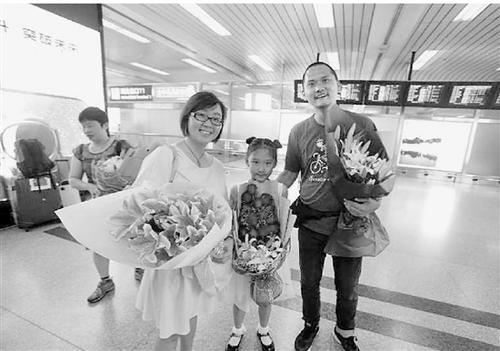 中国侨网妻子和女儿去机场迎接吴高飞回家。