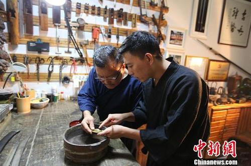中国侨网闫鹏(右)与父亲闫民的工作照。闫鹏供图