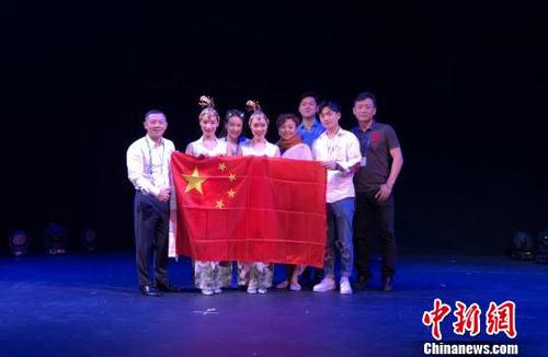中国侨网图为《伞丛扇影》节目组在美国比赛现场合影。　重庆杂技艺术团供图