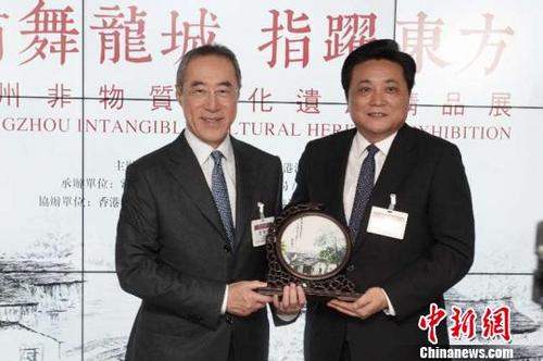 中国侨网中共常州市委常委、统战部部长韩九云(右一)在常州非物质文化遗产精品香港特展开幕仪式上向香港江苏社团总会会长唐英年(左一)赠送非遗作品。 龙曼 摄
