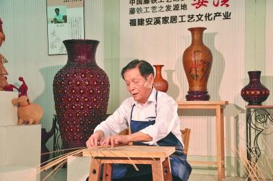 中国侨网陈清河在制作竹藤作品。