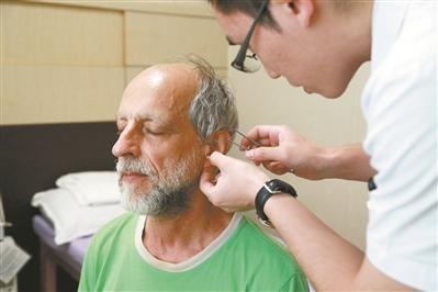 中国侨网医生为养生团成员做理疗。