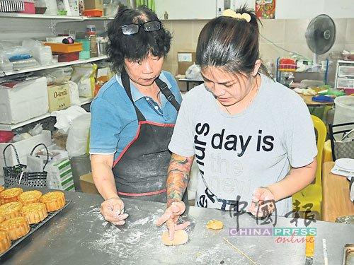 中国侨网邬碧云应顾客要求，教授月饼制作。（马来西亚《中国报》）