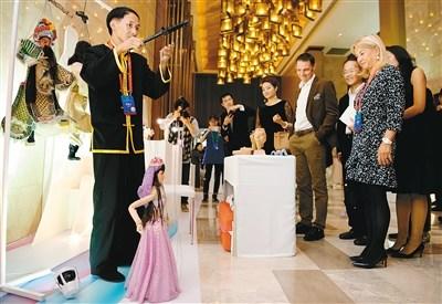 中国侨网法国嘉宾被中国的“非遗”精品吸引驻足。(记者 尚洪涛 王健 翟晓雪 摄)