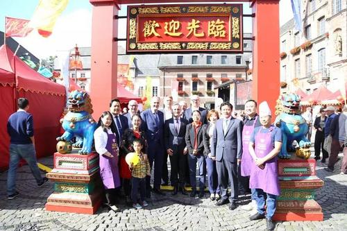 中国侨网嘉宾与德国中餐协会代表在中式大门前合影。
