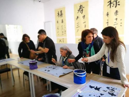 中国侨网活动现场,嘉宾们体验写书法。