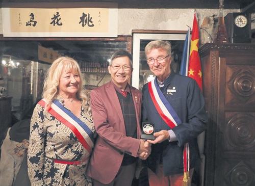 中国侨网热涅市市长乌赫德（右）为黄建南（中）颁发了金质“荣誉市民”奖章。左为巴黎19区副区长马莱。（法国《欧洲时报》/孔帆 摄） 