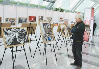 中国侨网一名韩国观众参观“40年，那些难忘的瞬间”图片展。 　　本报记者 马 菲摄 