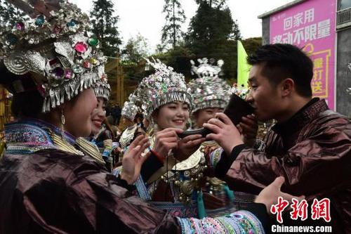 中国侨网苗族女孩在村口用牛角向来宾敬酒。　王以照　摄