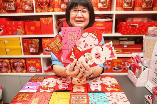 中国侨网商家展示几款设计可爱又特别的精美红包封。（新加坡《联合早报》/谢智扬 摄）
