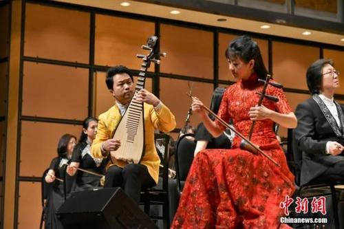 中国侨网资料图,当地时间1月23日、24日,“欢乐春节·华韵盛典”民族交响新春音乐会在加拿大多伦多连演两场,受到当地观众热烈欢迎。由中国广播民族乐团、中国广播艺术团和加中文化发展协会联合主办的该音乐会,是中国驻多伦多总领馆领区2019年“欢乐春节”重点活动之一。图为胡琴演奏家姜克美(红衣者)等在演出中。中新社发 马淼 摄