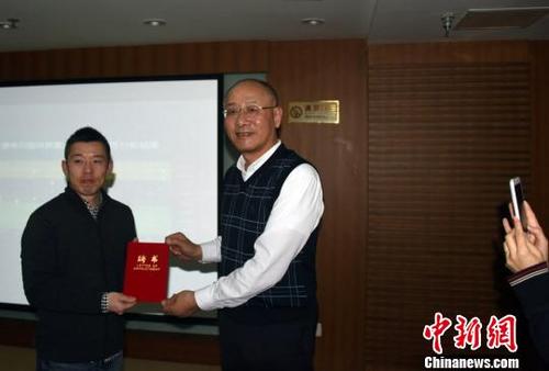 中国侨网讲座结束后,主持讲座的中国社会科学院考古研究所研究员袁靖向菊地大树(左)颁授聘书。 孙自法 摄