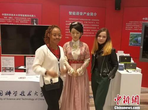 中国侨网外国留学生与“佳佳”机器人合影。　刘高威　摄