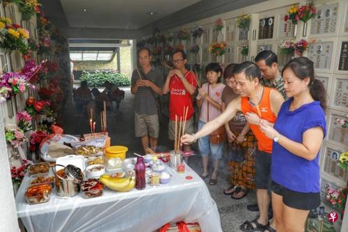 中国侨网郑利芳(右一)和她的家人每年都会依照潮州人的习俗准备供品,同时自备桌子,以便在祭拜时能摆放供品。(新加坡《联合早报》/林国明 摄)