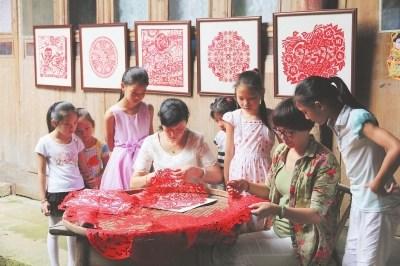 中国侨网在公益剪纸培训班上，孩子们正围着“剪花嫂”学习剪纸。 本报通讯员 徐强　摄