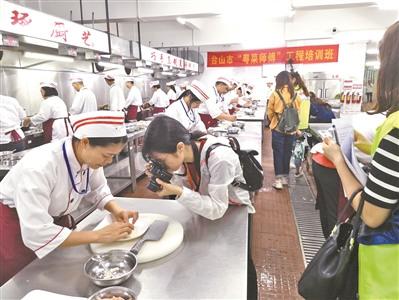 中国侨网台山广东厨艺技工学校“粤菜师傅”工程培训班学员正在进行烹饪练习。
