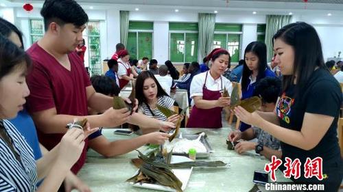 中国侨网餐厅厨师向留学生现场传授包粽子诀窍。　杨伏山　摄