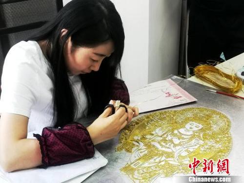 中国侨网    图为艺人正在制作掐丝唐卡。　李隽　摄