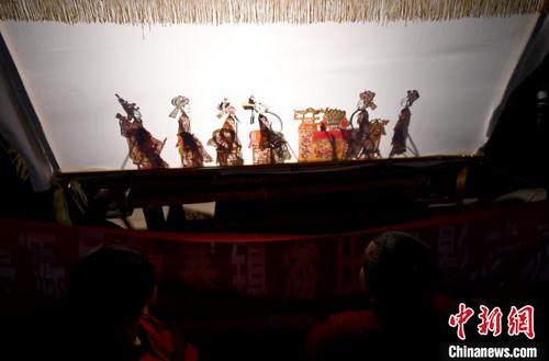 中国侨网 近日，甘肃定西市渭源县皮影戏是省非物质文化遗产，当地夜间“搭台唱影”引村民前来观看，热闹非凡。　吴鲁　摄