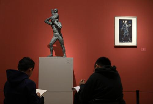 中国侨网两位参观者现场临摹熊秉明的铜雕作品《父与子》。(《欧洲时报》/李国庆 摄)