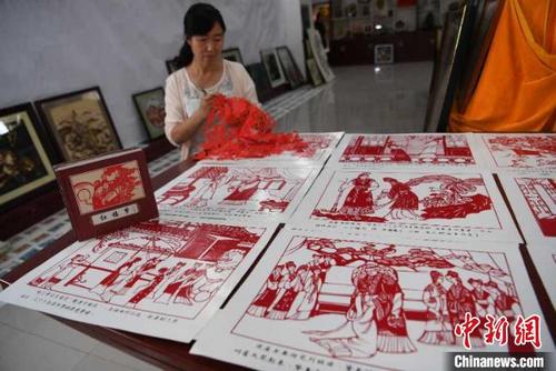 中国侨网7月，山丹县剪纸艺人周玉梅正在进行剪纸作品。　杨艳敏　摄