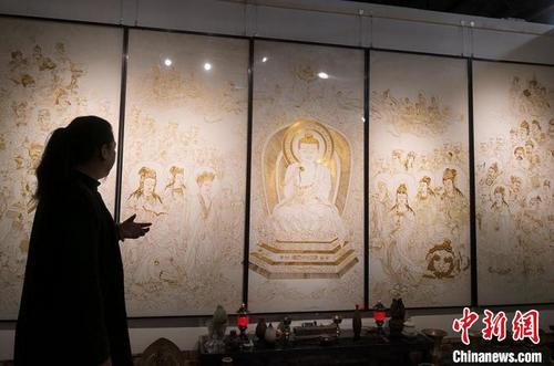 中国侨网2020年5月28日,掐丝珐琅画甘肃代表性传承人、中国非遗艺术设计研究院研究员李海明用长千余米仿金丝创作作品《说法图》,其用3000多米仿金丝、历时3年创作,作品长4.5米、高2米,其内容包括人物95个、瑞兽2只,掐丝勾勒出的人物神态、服饰、动作等栩栩如生。(资料图) 刘玉�