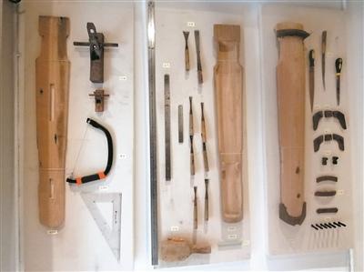 中国侨网岭南派古琴名家谢东笑工作室的墙上，展示着各种斫琴工具和古琴半成品。