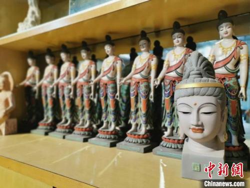 中国侨网8月底,甘肃敦煌八旬彩塑手艺人鲁勤学的彩塑厂内,展示柜上整齐地摆放着敦煌彩塑工艺品。 闫姣 摄