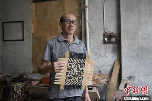 中国侨网谢世仰展示制作完成的竹编二维码。 彭莉芳 摄
