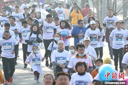 中国侨网跑友们统一着装沿着南京玄武湖奔跑。　泱波　摄