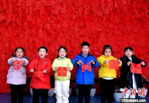 中国侨网12月30日，小朋友们展示自己亲手制作的剪纸窗花。韩苏原摄