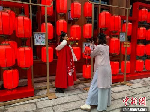 中国侨网不少游客手提花灯在万寿宫历史文化街区内“打卡”拍照留念。　李韵涵　摄