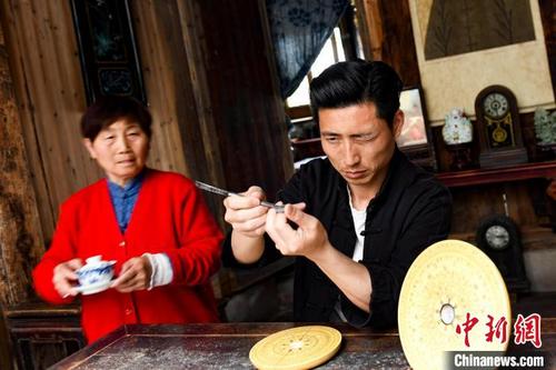 中国侨网吴兆光(右)在安装指针。 张娅子 摄