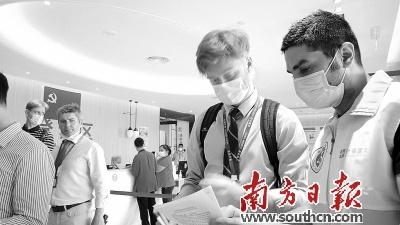 中国侨网伊朗小伙阿里（右）为外籍人士提供帮助。南方日报记者 吴伟洪 摄