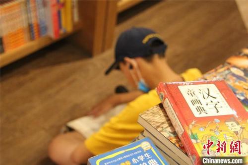中国侨网图为书店内,席地而坐认真阅读的小学生。 李明明 摄