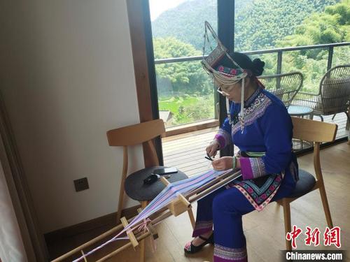 中国侨网非遗传承人钟杏秀正在编织畲族彩带。　王逸飞　摄