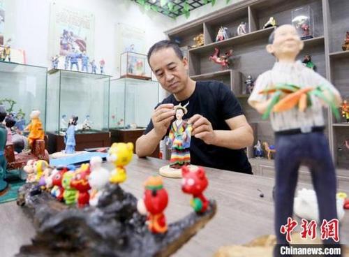 中国侨网8月31日，甘肃省非遗项目成州面塑传承人安秋平在用混有高粱、糯米的面泥制作面塑作品。　高展 摄