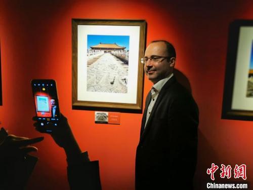 中国侨网 一位驻华外交官兴奋地在自己作品前合影 应妮 摄
