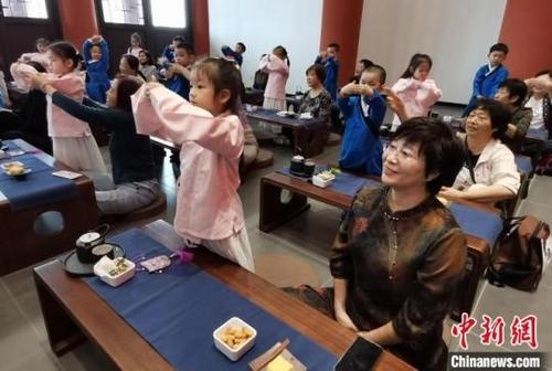 中国侨网小朋友学习奉茶古礼向长辈敬茶。谷华摄