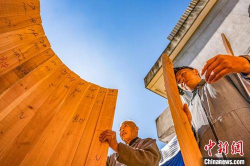 中国侨网70岁的谢歌美（左）和儿子谢丹桂正按序号拼鼓身。　赵春亮　摄