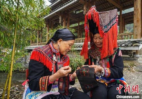 中国侨网图为邓正姣(右)在展示瑶族反面刺绣手工技艺。 唐梦宪 摄