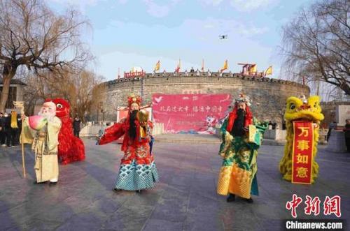 中国侨网福禄寿三星将装有祭祀圣果、糕点、灶糖、福卡的福袋和新年好福气传递给现场游客。　房体朔　摄