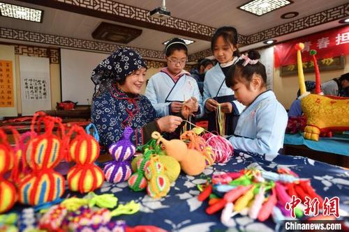 中国侨网民间艺人向孩子们传授手编葫芦技巧。　王海滨　摄