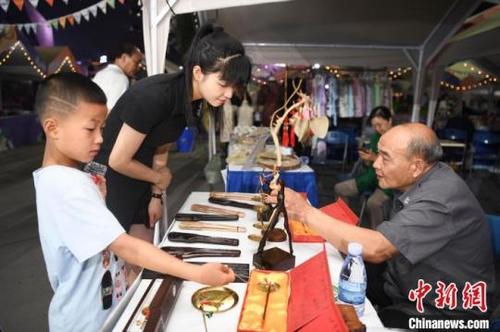 中国侨网手工杆秤制作技艺市级代表性传承人文志飞(右)向市民介绍手工艺作品。 杨华峰 摄