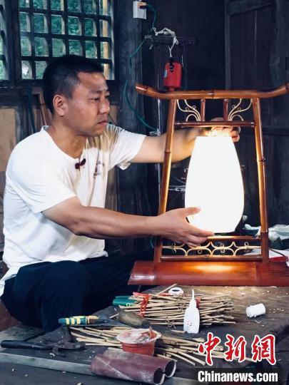 中国侨网国家级“非遗”小郁竹艺传承人危禄绵和他制作的工艺品。　受访者供图