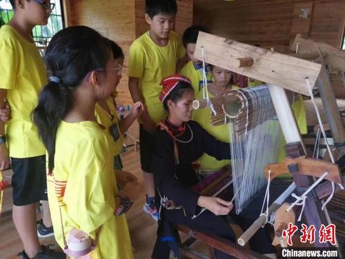 中国侨网织娘在教孩子们编织壮锦。　庞万雯　摄